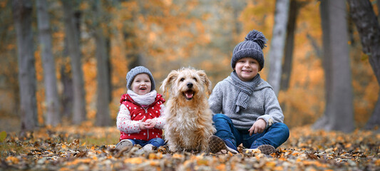 lachende Kinder mit Hund im Wald