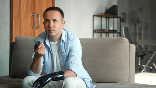 Guy with bio limb prothesis switches television with remote