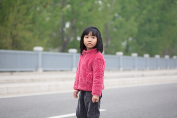 Obraz premium A five-year-old Chinese girl turns her head and looks into the distance