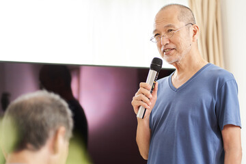 介護施設のカラオケルームで歌う高齢者