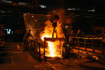 Iron casting. Molten metal pouring from blast furnace into ladle. Steel production in foundry...