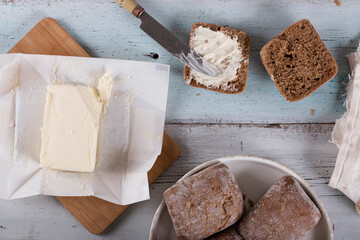 Buns of flour with bran with butter on a wooden table, top view