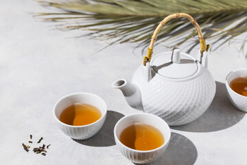 Asian tea ceremony. Teapot and tea cups with tea drink on table.