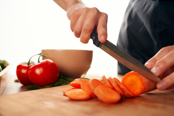 slicing carrots on a cutting board with a knife fresh vegetables cooking