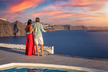 A couple at summer vacations holds hands and enjoys the view over the mediterranean sea during...