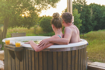 Young couple enjoy outside ofuro japanese hot tub in nature