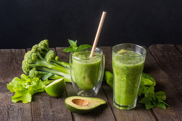 Fresh green smoothie in glass on wooden table, closeup.  Detox diet concept: green vegetables on rustic table. Clean eating, alkaline diet, weight loss food concept.