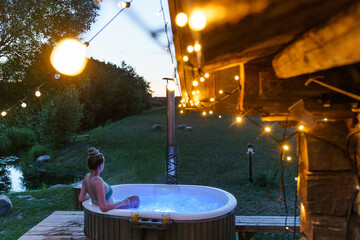 Young couple enjoy outside ofuro japanese hot tub in romantic environment. Idyllic bathtub in dark