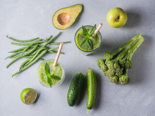 Fresh green smoothie in glass on wooden table, closeup.  Detox diet concept: green vegetables on rustic table. Clean eating, alkaline diet, weight loss food concept.