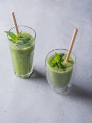Fresh green smoothie in glass on wooden table, closeup.  Detox diet concept: green vegetables on rustic table. Clean eating, alkaline diet, weight loss food concept.