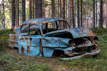Old retro car abandoned in a forest in Sweden