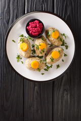 Classic Gefilte Fish Gently cooked fish patties in the simmering fish stock closeup in the plate on the tble. Vertical top view from above