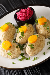 Classic Gefilte Fish Gently cooked fish patties in the simmering fish stock closeup in the plate on the tble. Vertical