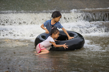 a kids play and lying on a tire floating in water Filmed in Chiang mai, Thailand.
