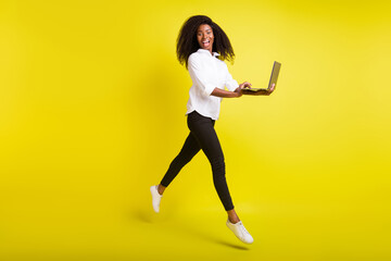 Fototapeta na wymiar Full length body size photo young woman jumping using laptop isolated bright yellow color background