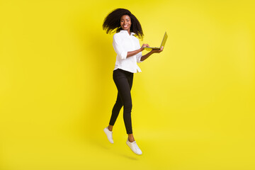 Full length body size photo young woman jumping up browsing internet computer isolated vivid yellow color background