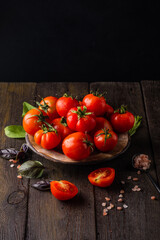 Fresh tomatoes in a plate on a dark background. Harvesting tomatoes. Top view
