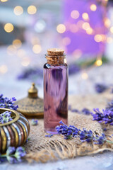 Lavender oil and lavender flowers on bokeh background.