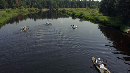Obraz premium Drone point view of group people kayaker floating on water. Aerial drone view of group kayak in lake. Kayaking and Canoeing along the Riverbed Aerial View. Rafting. Tracking a Boat