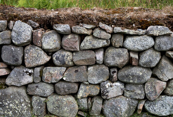 Stone Boulder Wall Topped with Turf in a Field