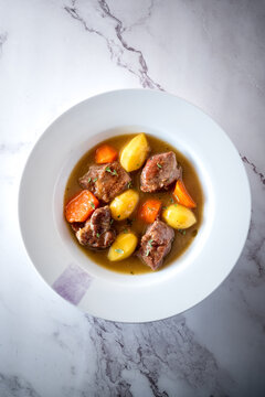 Tasty stew with vegetables and meat in plate on table