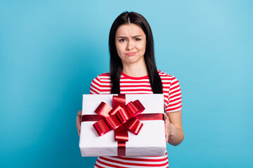 Photo of young girl unhappy sad upset negative dislike surprise present box isolated over blue color background