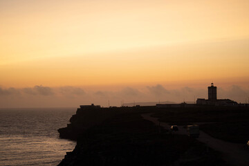 Lighthouse on the coastline at sunset, summer day