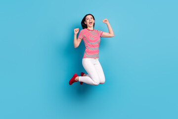 Full body profile side photo of young girl happy positive smile jump rejoice victory fists hands isolated over blue color background