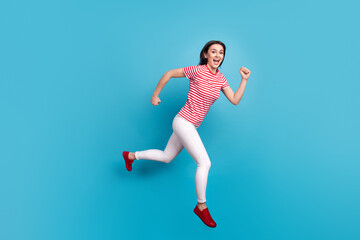 Fototapeta na wymiar Full size profile side photo of young girl happy positive smile jump go walk run hurry isolated over blue color background
