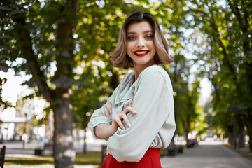 pretty woman walking in the park in red skirt outdoors