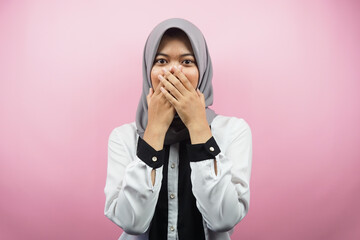 Beautiful young asian muslim woman shocked, surprised, disbelieving, getting shocking information, with hands covering mouth isolated on pink background