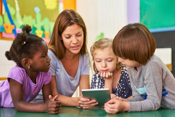 Children and educators reading aloud from an ebook - obrazy, fototapety, plakaty
