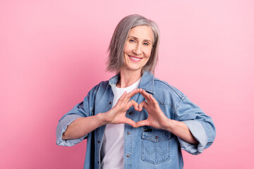 Photo of feel young flirty elder lady show heart wear blue blazer isolated on pastel pink color...