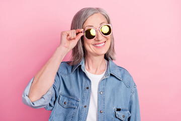Photo of funny elder lady hand eyewear look empty space wear blue shirt isolated on pink color background