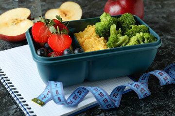 Diet concept with lunch box on black smokey table