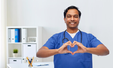 healthcare, profession and medicine concept - happy smiling indian doctor or male nurse in blue...