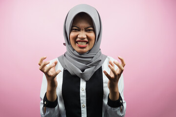 Beautiful young asian muslim woman shocked, dizzy, stressed, unhappy, many problems, want solution, with hands up isolated on pink background