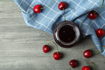 Naklejka na ściany i meble Cherry jam and ingredients on gray textured table