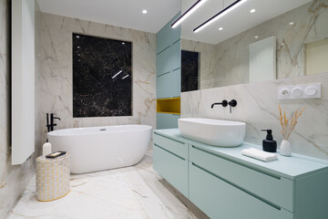 Elegant bathroom with bathtub and blue furniture - 446404866