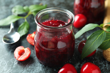 Cherry jam and ingredients on black smokey table