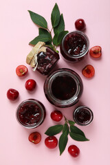 Cherry jam and ingredients on pink background