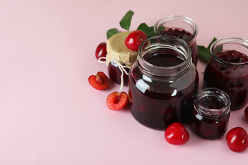 Cherry jam and ingredients on pink background