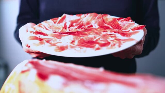Plate of delicious Iberian ham on a wooden table background with a ham knife and metal tongs. Appetizing slices of Iberian ham. Acorn-fed Iberian Ham. Typical Spanish or Catalan food. 4k video.