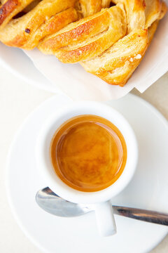 Top view to white cup of coffee ristretto and croissant. Traditional italian breakfast. Good morning concept. Daylight. Homemade bakery. Ginseng hot drink and apple pie 