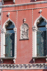 Architectural detail on facade of building between two windows in gotic style on Grand Canal, Venice, Italy