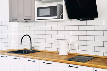 White cabinets with wooden counter of modern kitchen