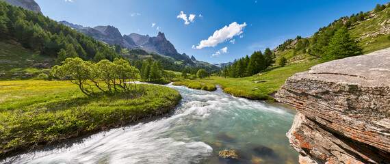 La Claree river in Summer with the famous Main de Crepin peak in the Cerces Massif mountain range....