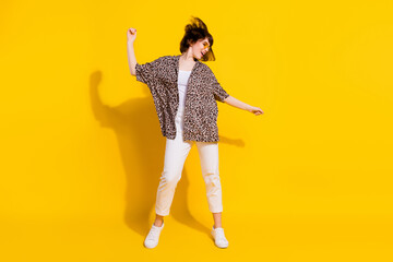 Full size photo of cool millennial lady dance wear eyewear shirt trousers sneakers isolated on yellow color background