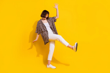 Full length profile photo of fancy millennial lady dance wear eyewear shirt trousers sneakers isolated on yellow color background