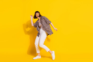 Full body photo of nice lady dance wear eyewear shirt trousers sneakers isolated on yellow color background